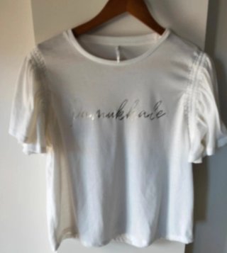 Camiseta blanca con texto plateado