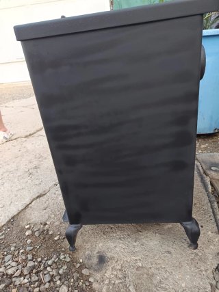 Chimenea de metal negra con ventana.