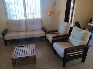 Sofá de 2 plazas beige y madera y 2 individuales.