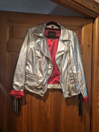Chaqueta plateada con flecos, muy bien forrada.