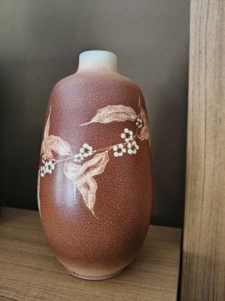 Jarrón de cerámica marrón con flores