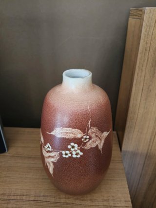Jarrón de cerámica marrón con flores