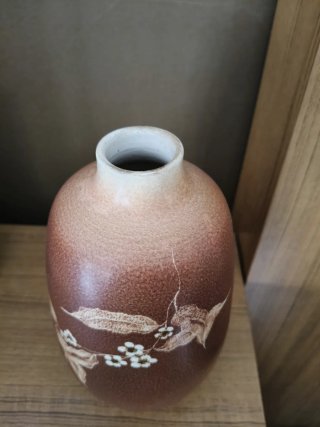 Jarrón de cerámica marrón con flores