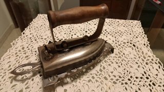 Plancha antigua de ropa con soporte