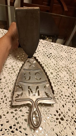Plancha antigua de ropa con soporte