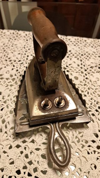 Plancha antigua de ropa con soporte
