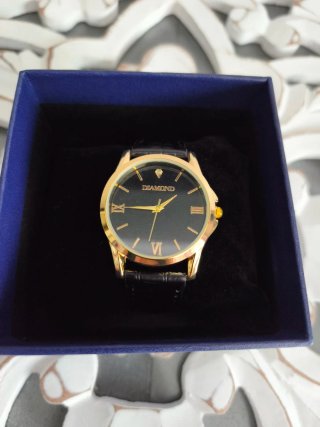 Reloj de pulsera dorado y negro con diamante
