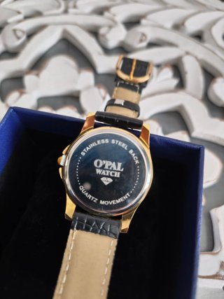 Reloj de pulsera dorado y negro con diamante