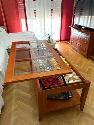 Mesa de centro elevable de madera y cristal.