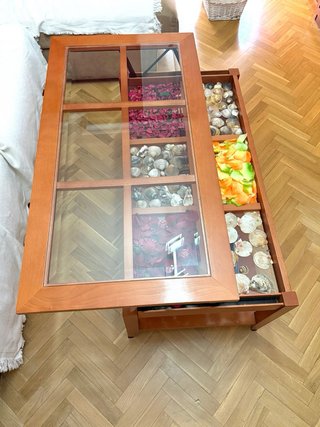Mesa de centro elevable de madera y cristal.