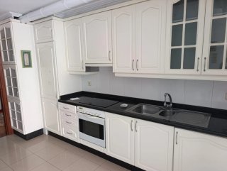 Cocina blanca y negra con muebles de madera