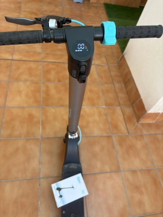 Patinete eléctrico Cecotec con cargador y casco.