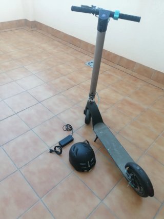 Patinete eléctrico Cecotec con cargador y casco.