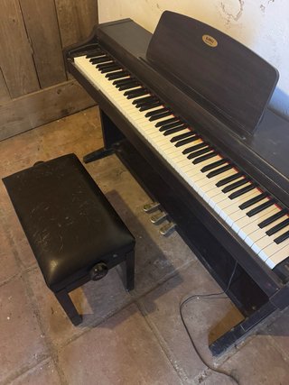 Piano digital KAWAI oscuro con banqueta