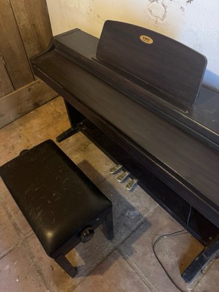Piano digital KAWAI oscuro con banqueta