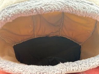 Cama para gato con cojín y juguetes.
