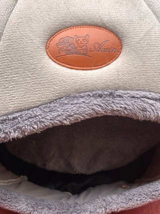 Cama para gato con cojín y juguetes.