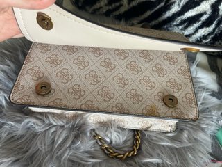 Bolso GUESS beige de cadena dorada.