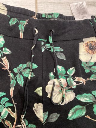 Pantaloni neri con fiori verdi