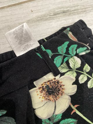 Pantaloni neri con fiori verdi