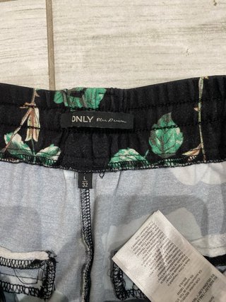 Pantaloni neri con fiori verdi