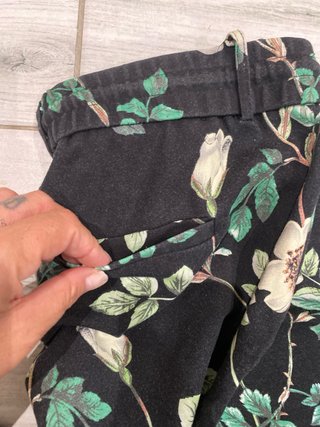 Pantaloni neri con fiori verdi