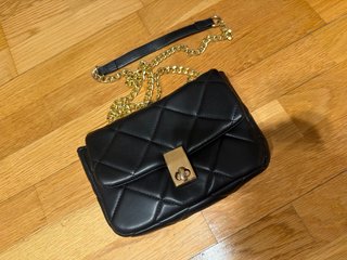 Bolso negro acolchado con cadena dorada