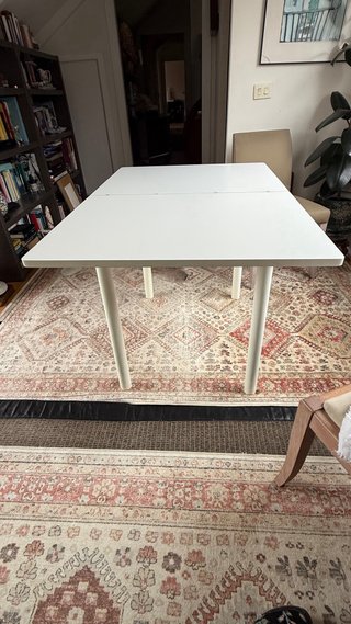 Mesa auxiliar extensible blanca con cajón.