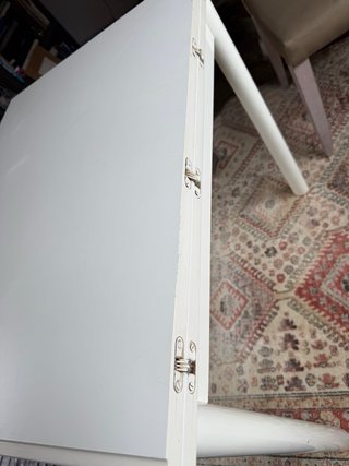 Mesa auxiliar extensible blanca con cajón.