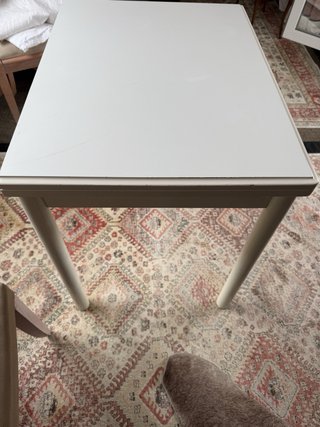 Mesa auxiliar extensible blanca con cajón.