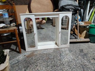Mueble de baño blanco con espejo, luces y enchufe.