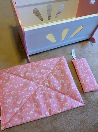 Cuna de madera rosa para muñecas