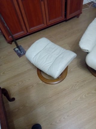 Sillón reclinable de piel beige con reposapiés