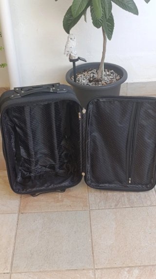 Maleta de viaje negra con detalles naranjas