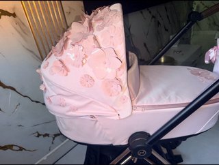 Carrito de bebé rosa con flores