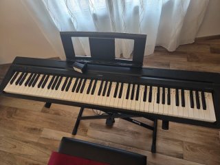 Teclado Yamaha con patas, pedal y banqueta.