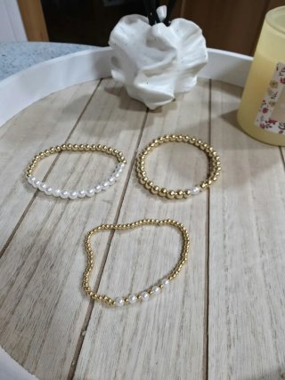 Pulseras doradas con perlas