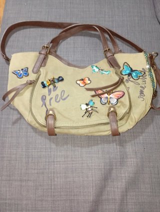 Bolso beige con adornos de mariposas y abejas