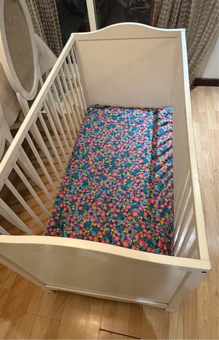 Cuna de bebé blanca con estampado floral