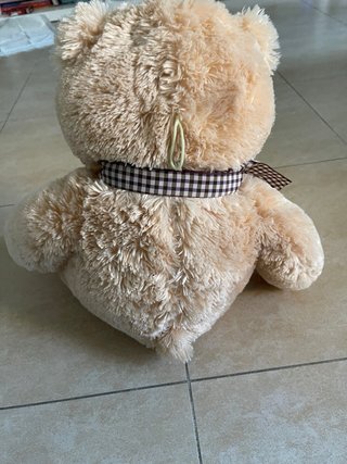 Oso de peluche marrón con lazo
