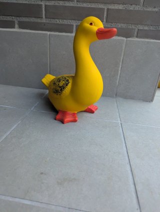 Pato de cerámica amarillo y rojo