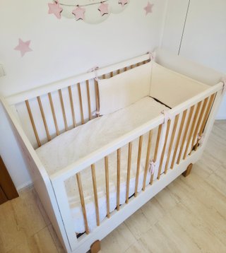 Cuna de bebé blanca con barrotes de madera