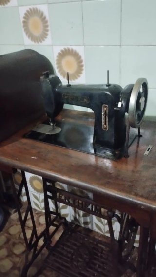 Máquina de coser antigua con pedal y base de mader
