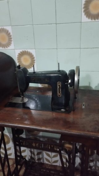 Máquina de coser antigua con pedal y base de mader