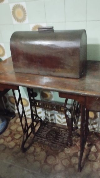 Máquina de coser antigua con pedal y base de mader