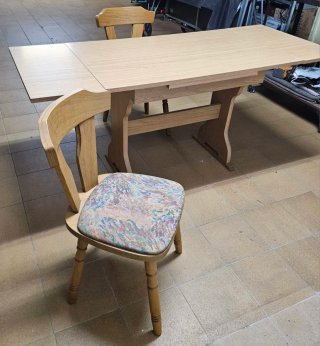 Mesa de comedor extensible de madera y dos sillas.