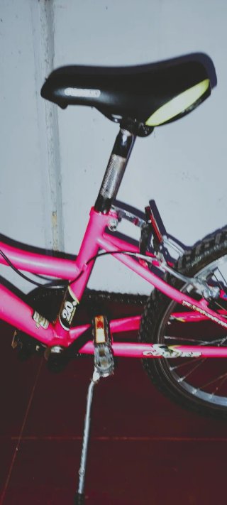 Bicicleta infantil rosa y amarillo fluorescente.