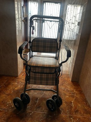 Andador con cesta y asiento para personas mayores.