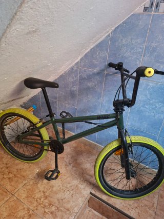 Bicicleta BMX verde con ruedas amarillas