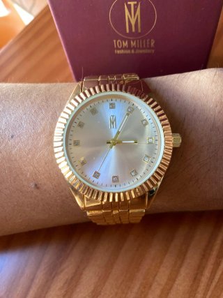 Reloj de pulsera dorado con detalles brillantes